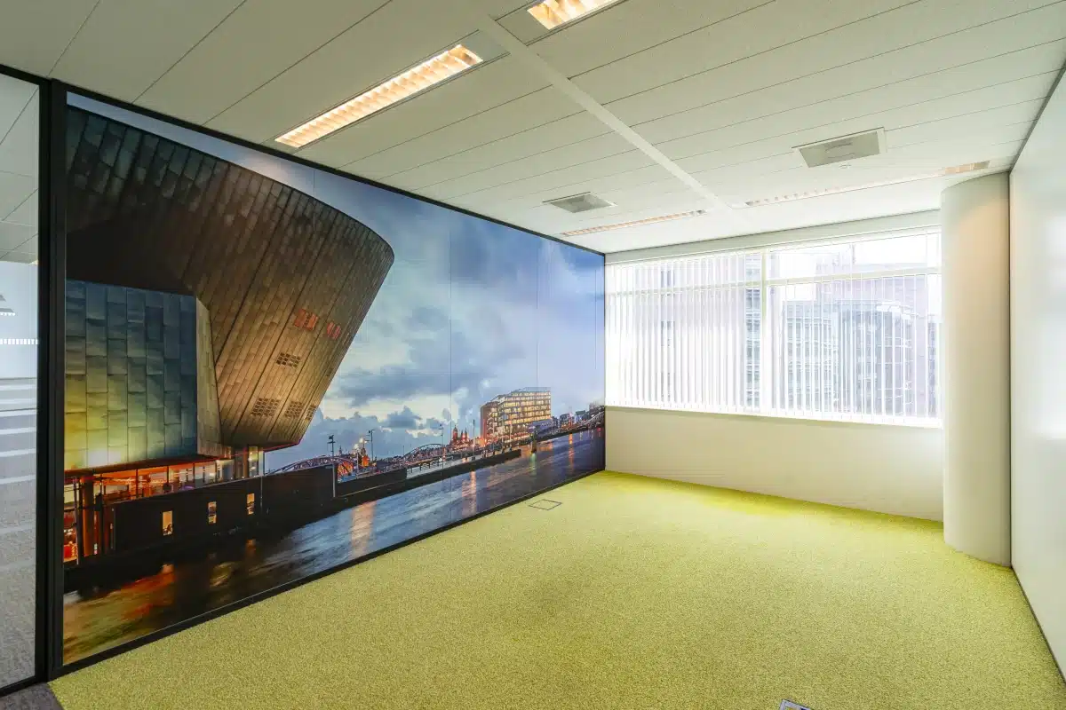 Bürofläche mit großem Wandbild des Amsterdamer Nemo Science Museum und grünem Teppich im Bright Offices Amsterdam