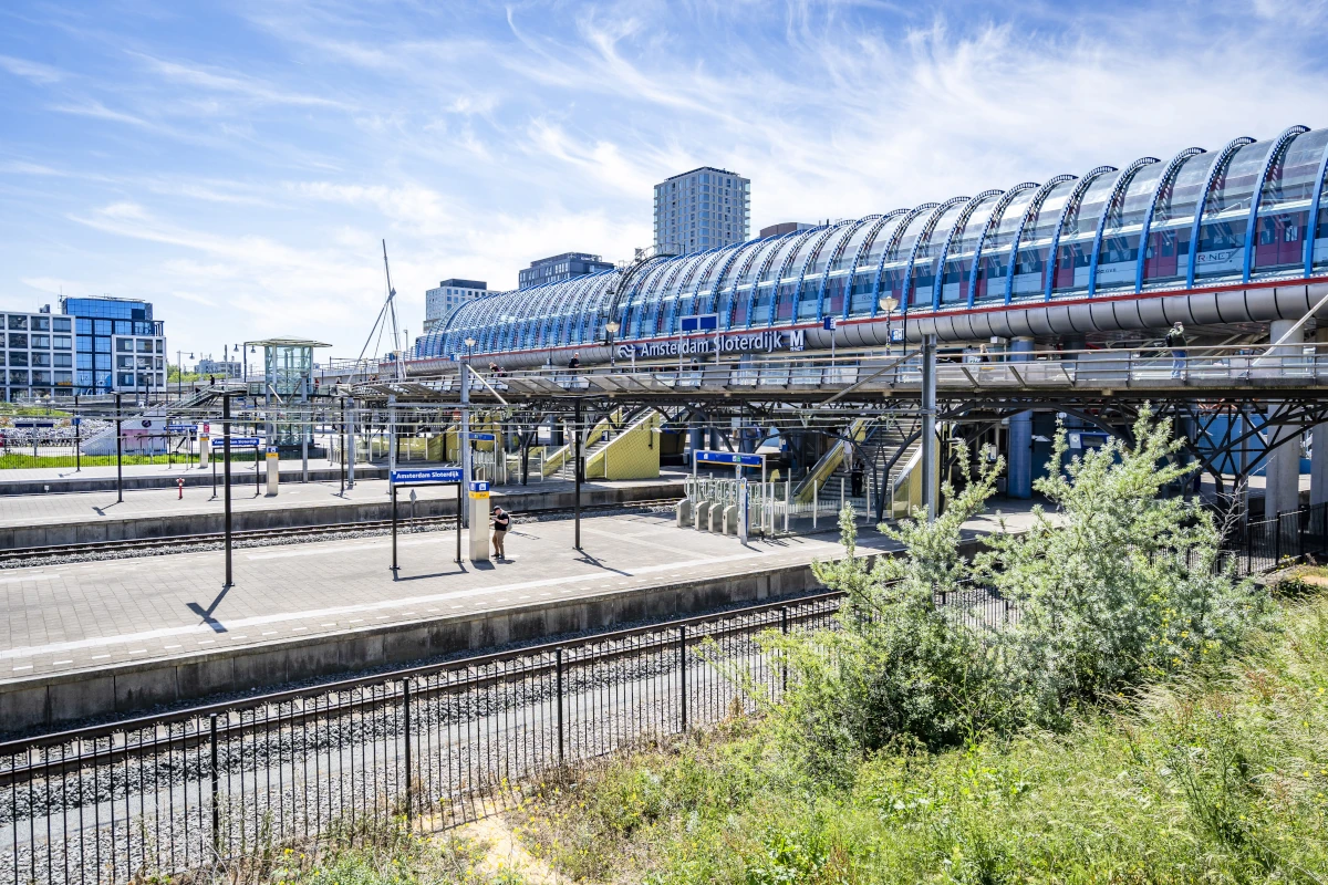 Bahnstation Amsterdam Sloterdijk mit überdachten Gleisen und moderner Architektur nahe Bright Offices