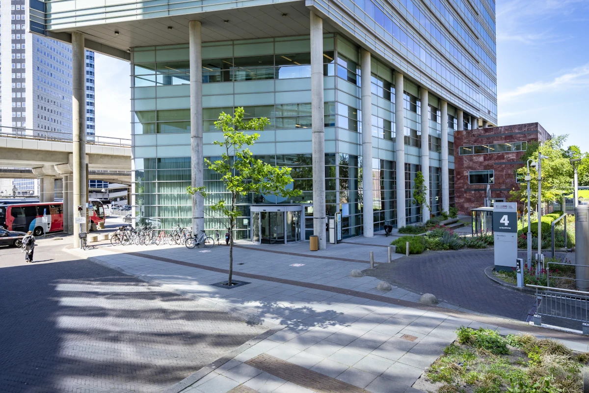 Breite Ansicht des Eingangsbereichs A mit Glasfassade und bepflanzten Grünflächen vor dem Bright Offices Amsterdam